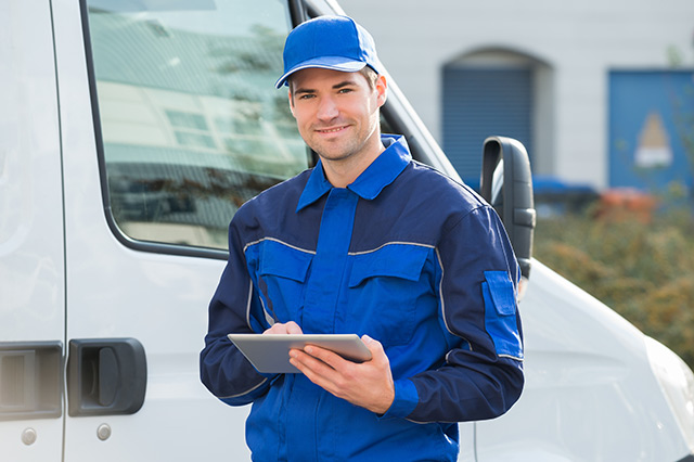 Worker with clipboard in front of a truck